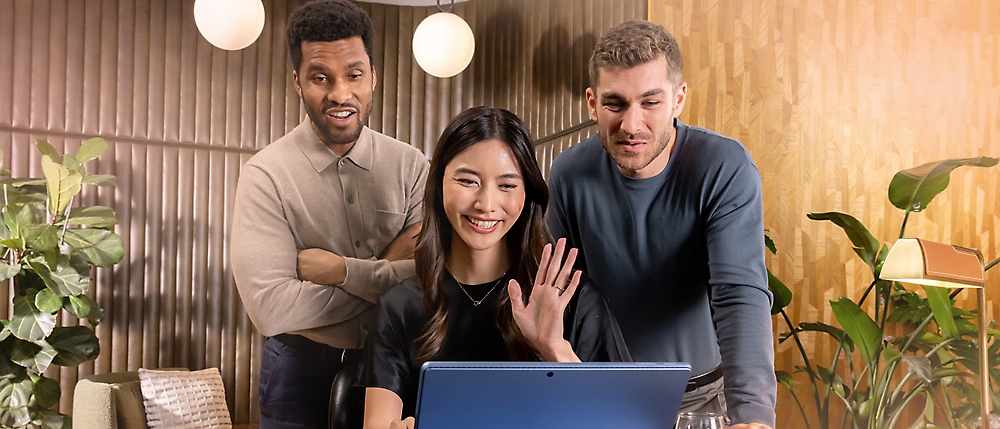 Des collaborateurs réunis autour d’un ordinateur — visuel Microsoft